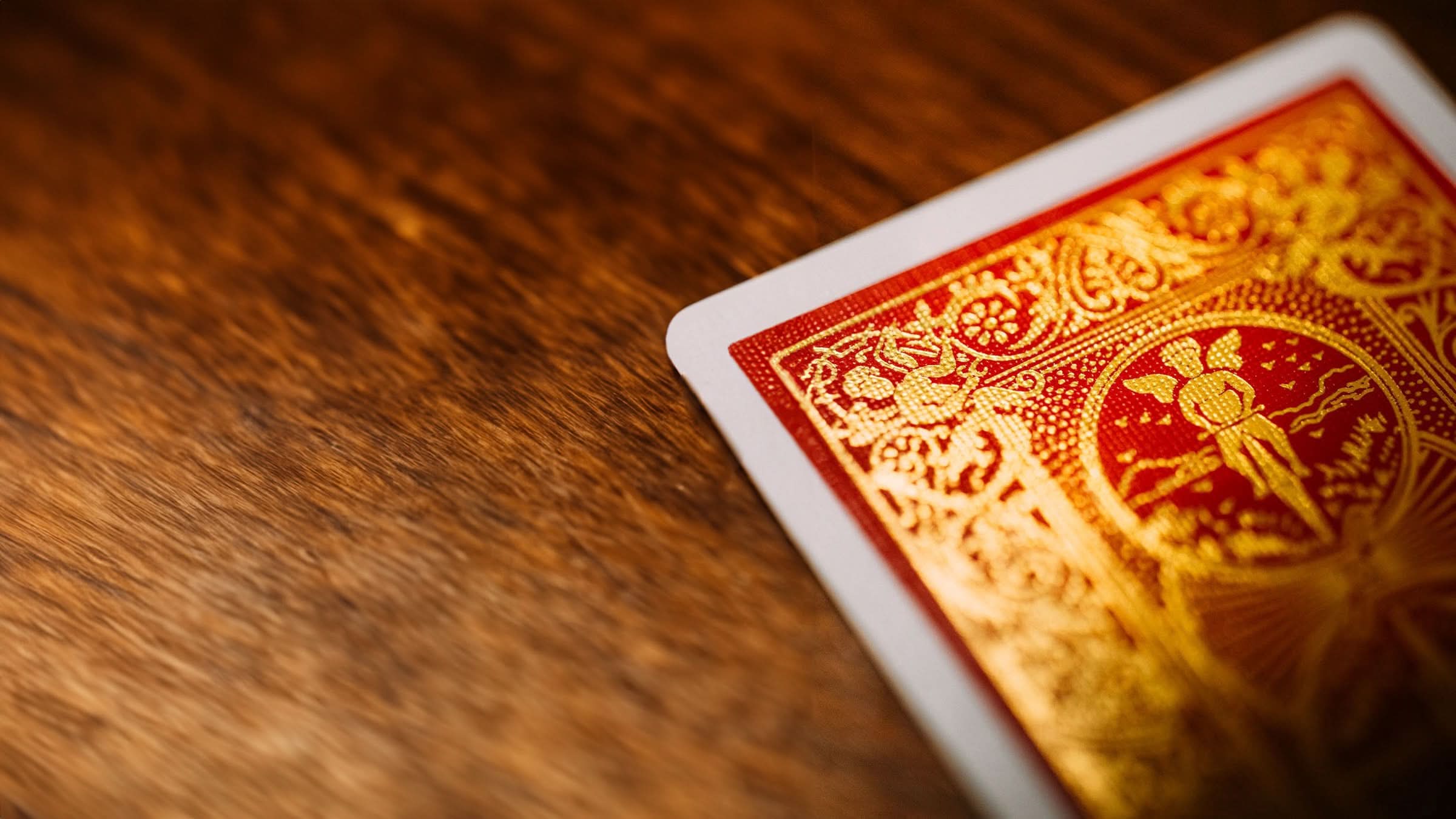 Close-up of a Bicycle 140th Anniversary playing card back, showcasing intricate gold foil details on a rich red background. A stunning deck for collectors, magicians, and card enthusiasts.Available at 52Kards for collectors, magicians, and card enthusiasts.