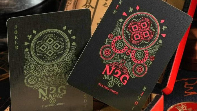 Black coinpix playing cards with red and green designs on a vintage-style box