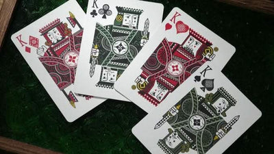 Four playing cards from the n2g coipix deck featuring kings from different suits on a green surface.