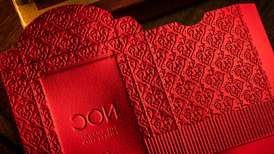 Red NOC Luxury tuck box beside its matching embossed sleeve