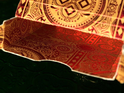 Decorative red and gold tuck box with intricate patterns on a dark background