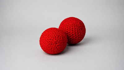 Two red crochet balls by Bazar de Magia on a neutral studio background