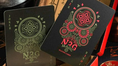 Black coinpix playing cards with red and green designs on a vintage-style box