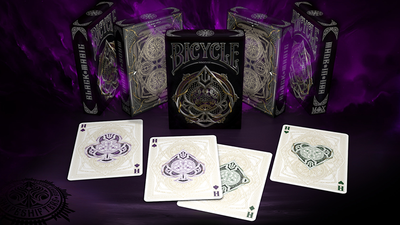 Bicycle Black Magic tuck boxes standing behind four face-up aces in purple and green variants