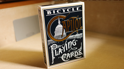 Bicycle Capitol tuck box standing upright on a tan surface