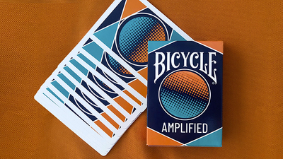Bicycle Amplified tuck box beside a diagonal spread of card backs